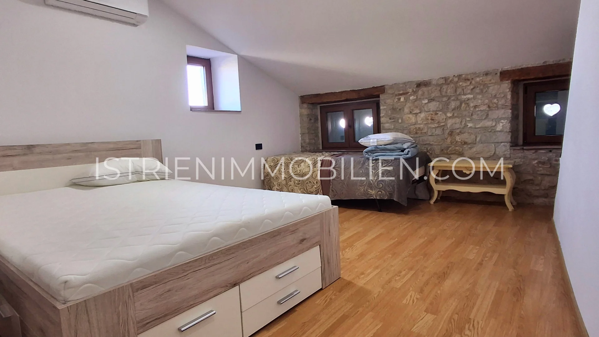 Schlafzimmer im charmanten Haus in Buje mit Steinwand und Holzboden