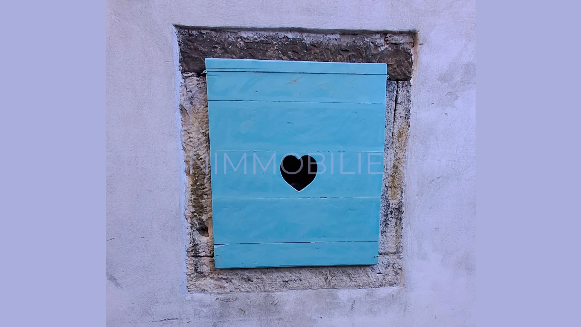 Detailaufnahme eines blauen Fensterladens an einem Haus in Buje