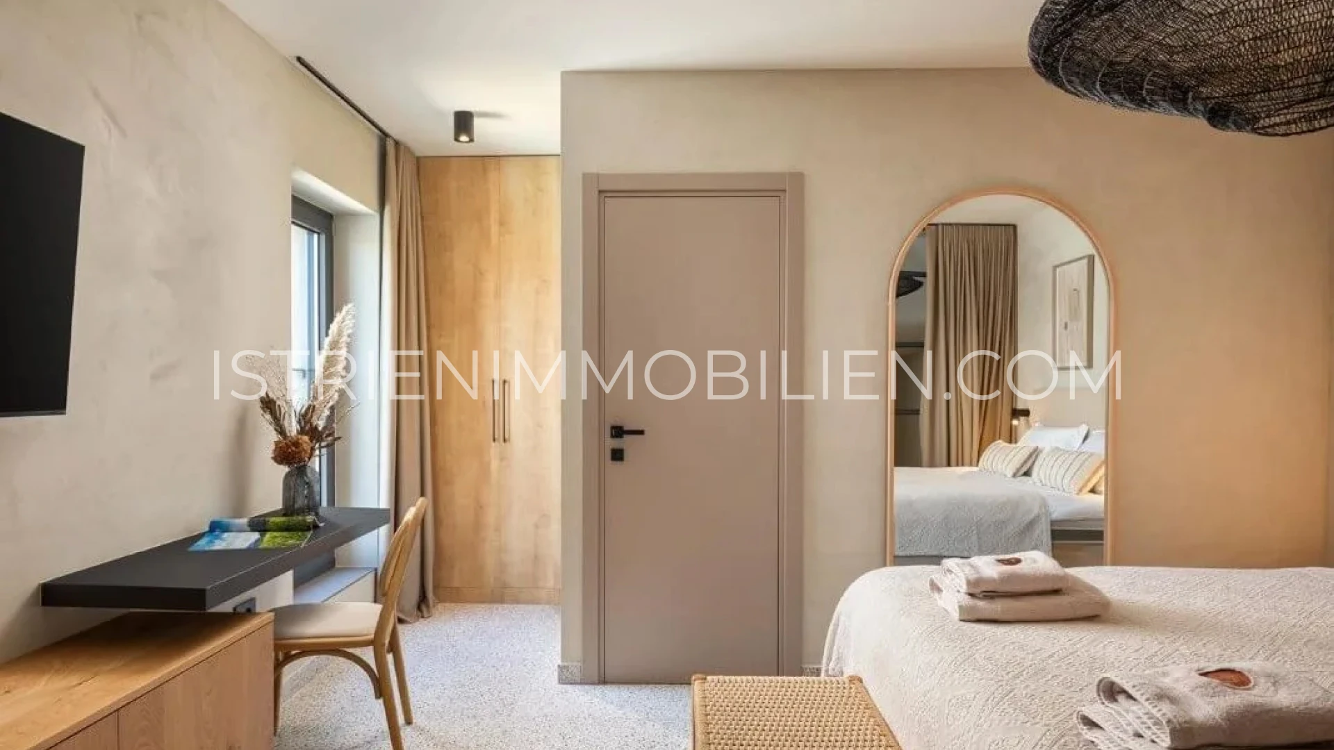 Schlafzimmer mit Holzeinbauten, Arbeitsplatz und großem Spiegel