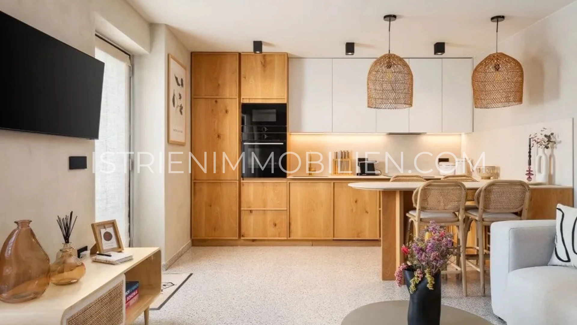 Offene Designküche mit Holzfronten, Esstheke und Wohnbereich im Natursteinhaus