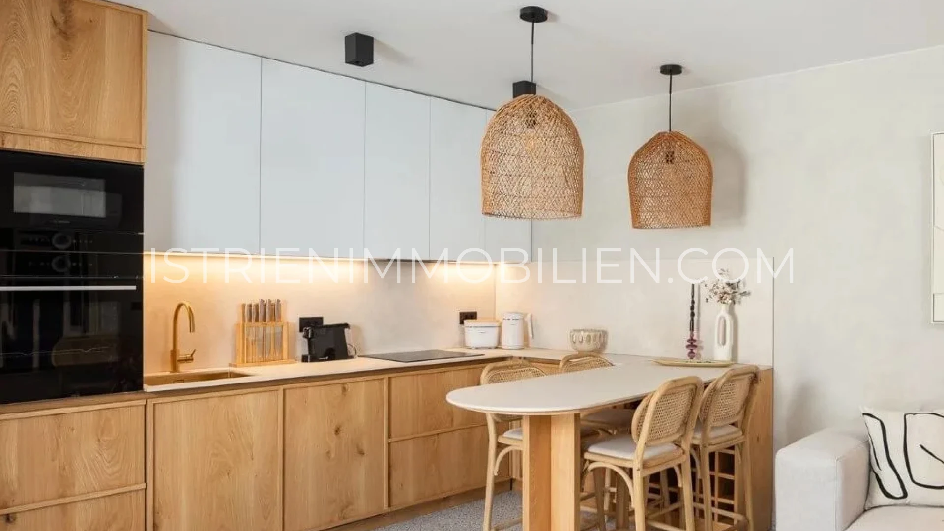Moderne Wohnküche mit Holzfronten, weißen Oberschränken und gemütlichem Essplatz